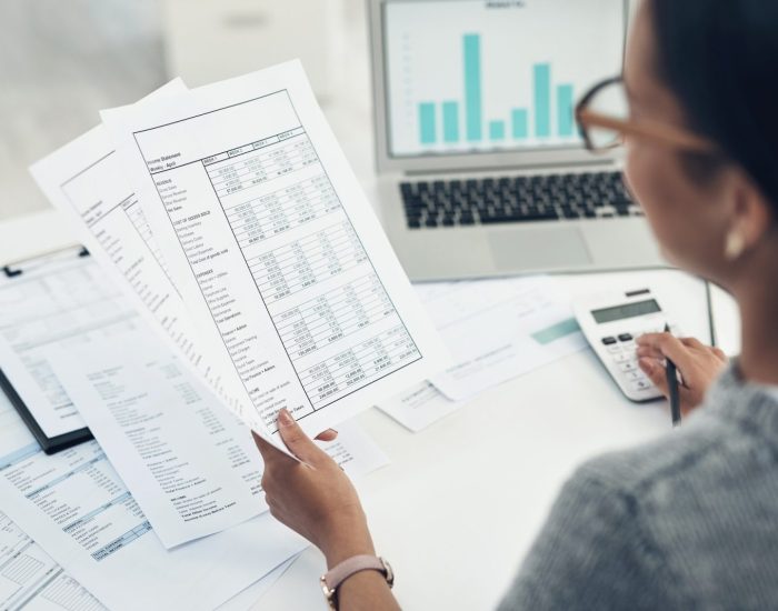 Closeup shot of an unrecognisable businesswoman calculating finances in an office